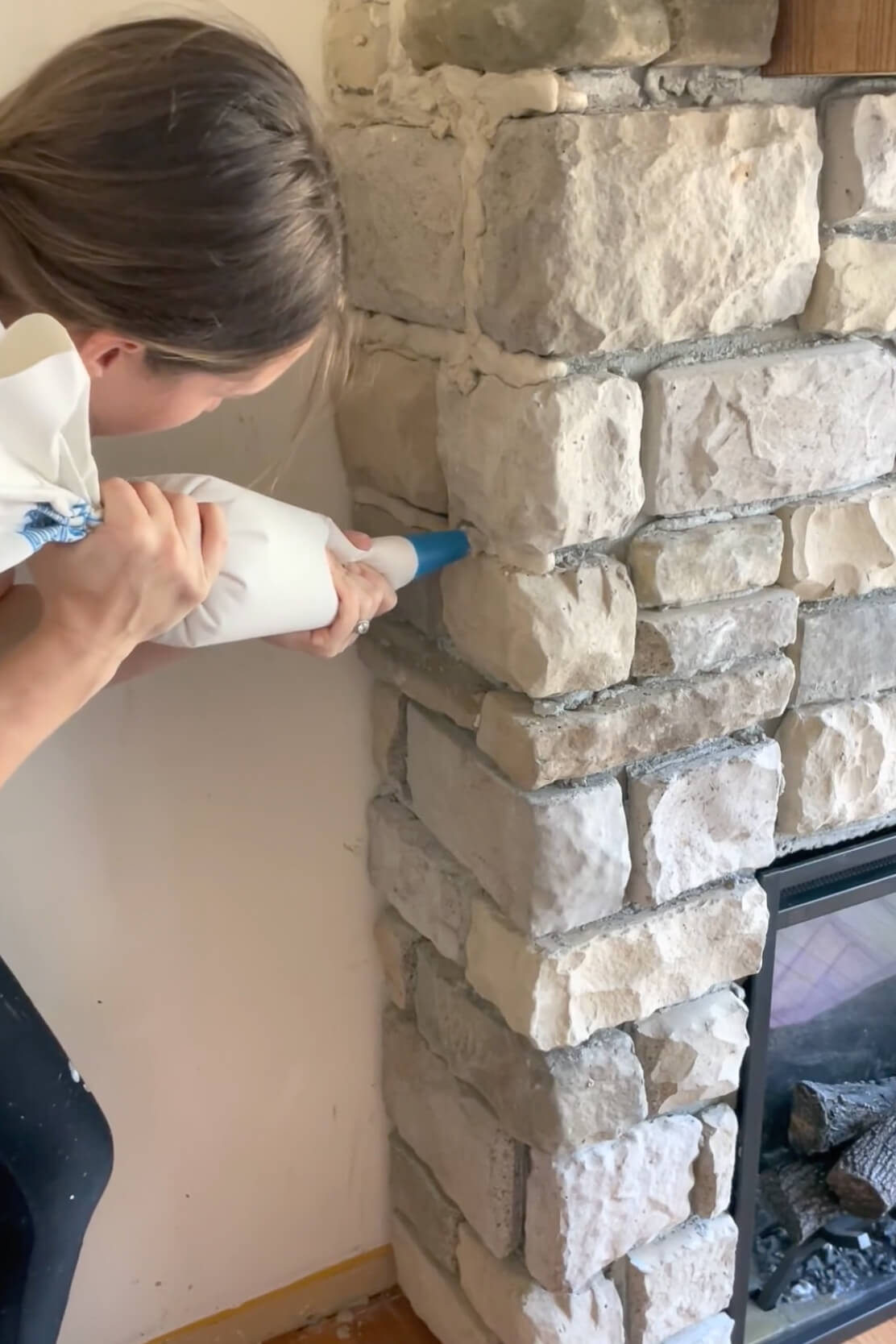 Using a grout bag to fill the space in between stones.